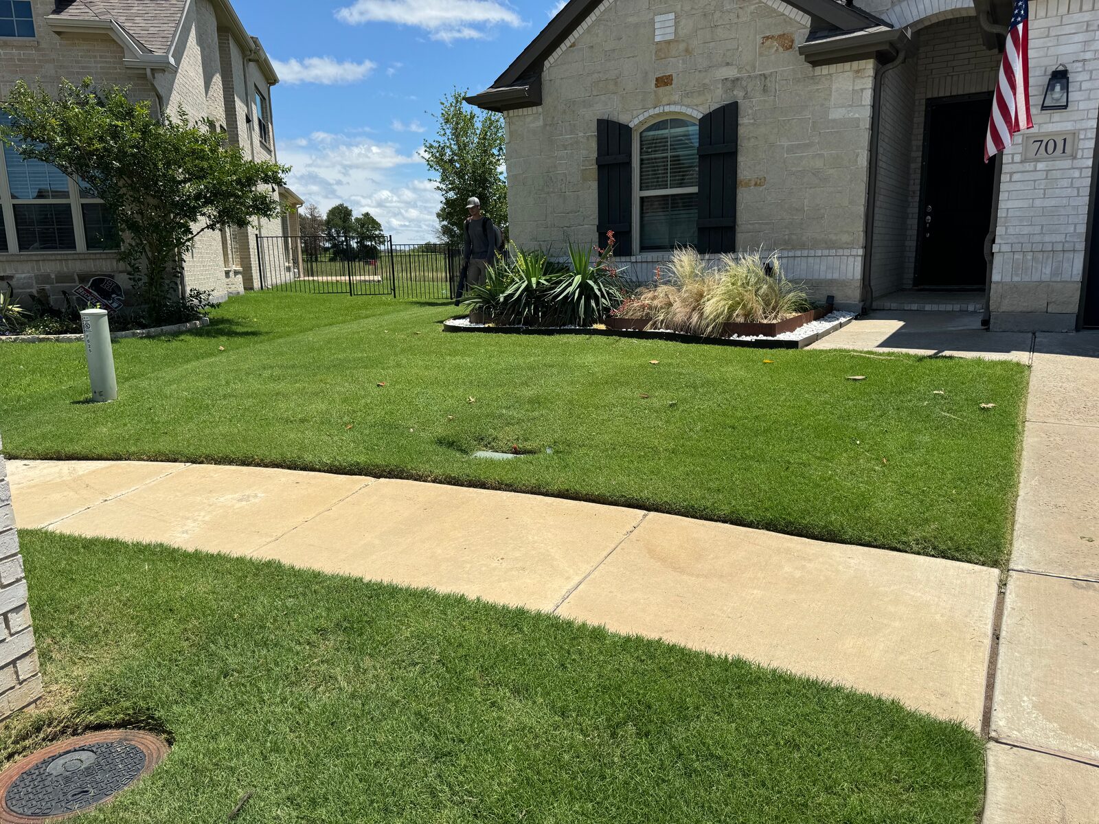 Wide front yard and driveway with uniform green turf
