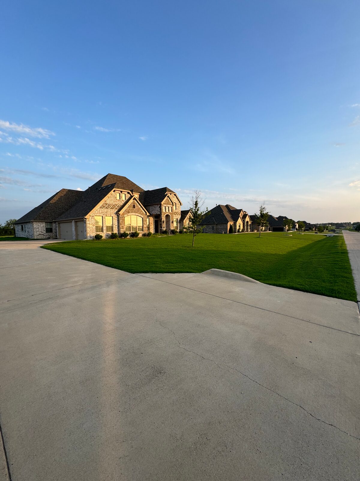 Sunset view of a healthy front lawn in a Rockwall County neighborhood